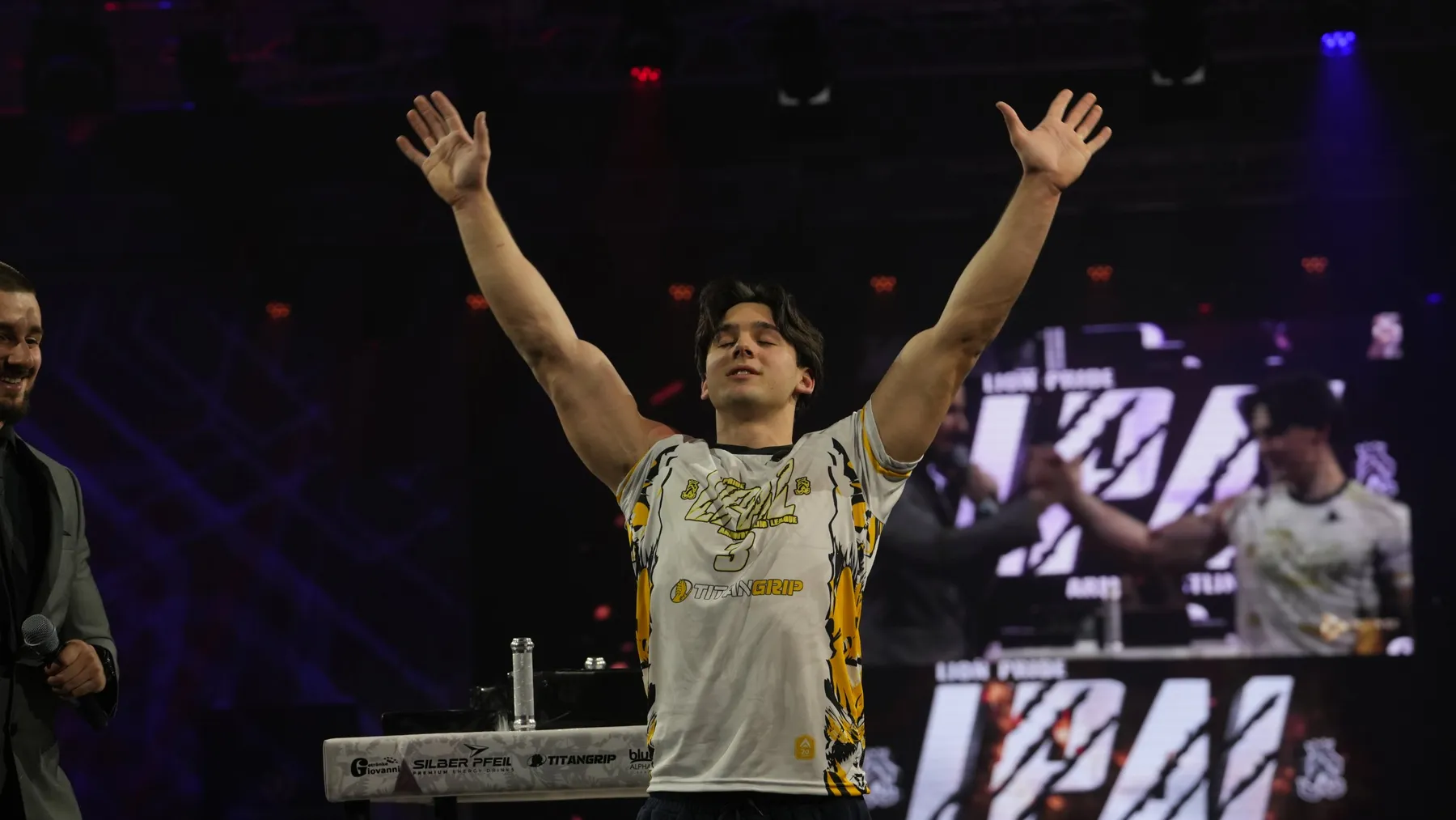 Ethan Lovei with his arms raised on stage